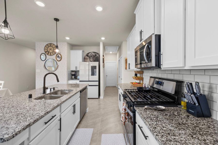 Details matter! This kitchen showcases its high-end finishes, from the black matte gooseneck faucet to the stainless steel dishwasher, gas-stove and microwave. The bright, modern design is both beautiful and functional, offering plenty of room for all your cooking needs.