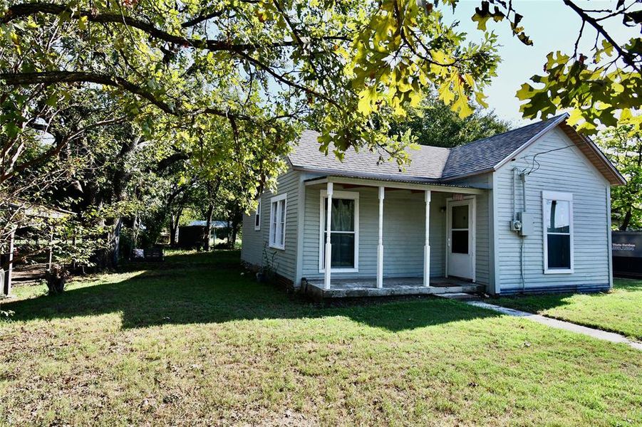 View of front of house featuring a porch, a shingled roof, and a front yard View of front of house featuring a porch, a shingled roof, and a front yard
