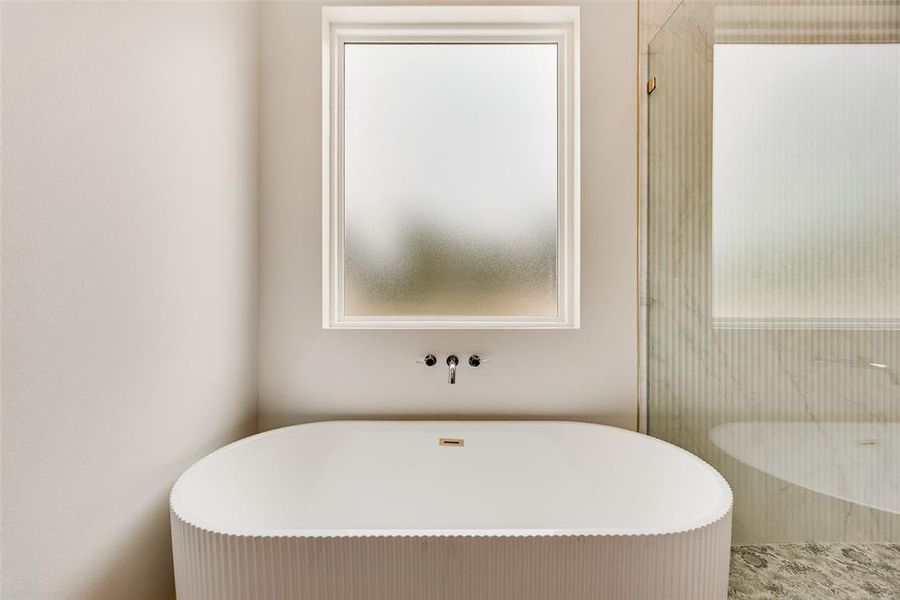 Full bath featuring a freestanding tub and a shower stall