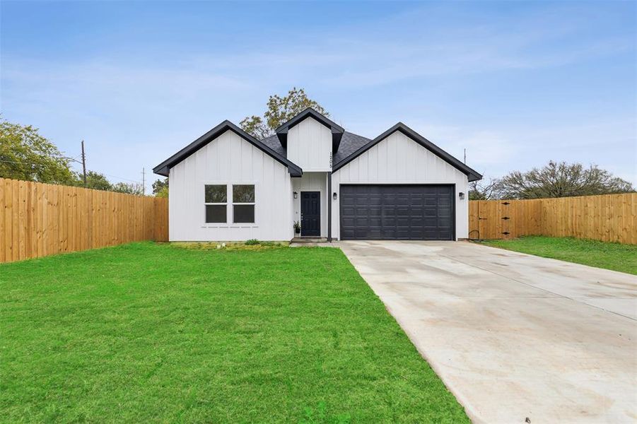 Modern farmhouse style home with a garage and a front yard