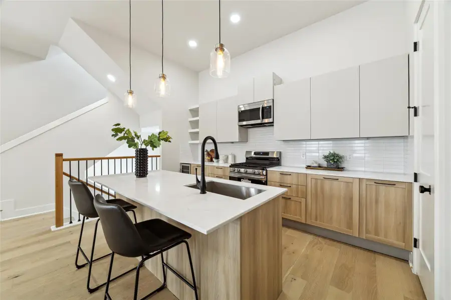Sleek, modern kitchen featuring stainless steel appliances, elegant cabinetry, and a spacious island with seating. Perfect for cooking and entertaining.