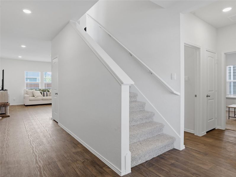 Gleaming wood flooring complements the carpeted staircase in this inviting entryway layout. Gleaming wood flooring complements the carpeted staircase in this inviting entryway layout.
