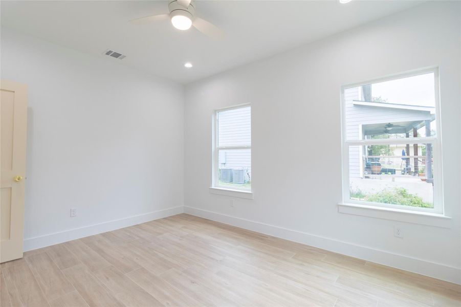 Unfurnished room featuring light wood finished floors, a ceiling fan, and recessed lighting