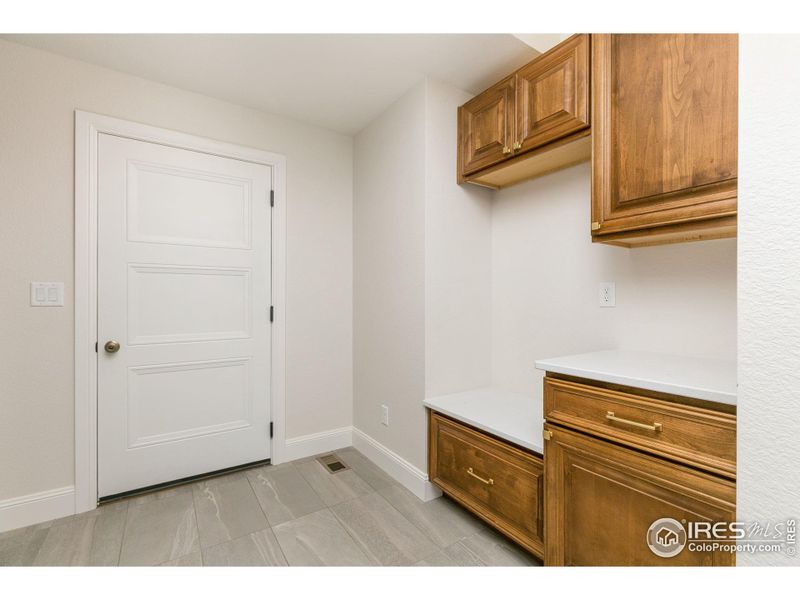 Next to the primary bedroom is the laundry/mudroom with a boot bench, drop zone and plenty of storage