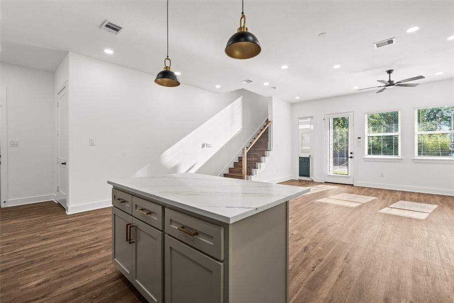 Natural light dancing across the room. The transition from the kitchen island to the open living space is completely effortless.