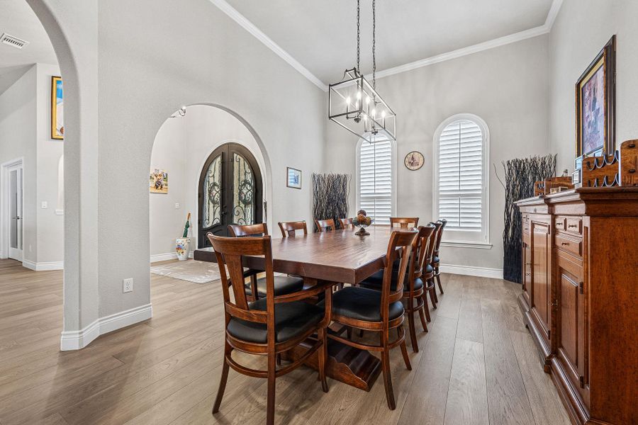 An inviting formal dining space features arched doorways and light hardwood flooring, perfect for gatherings. An inviting formal dining space features arched doorways and light hardwood flooring, perfect for gatherings.