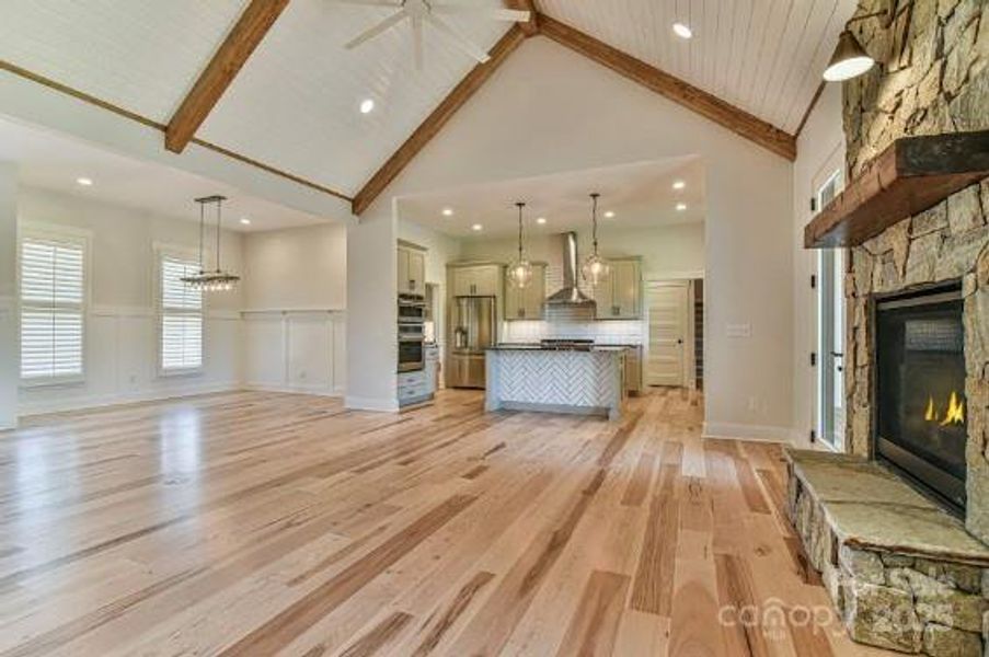 Open Floor Plan with a vaulted tongue and groove ceiling with stained beams. Similar photo.