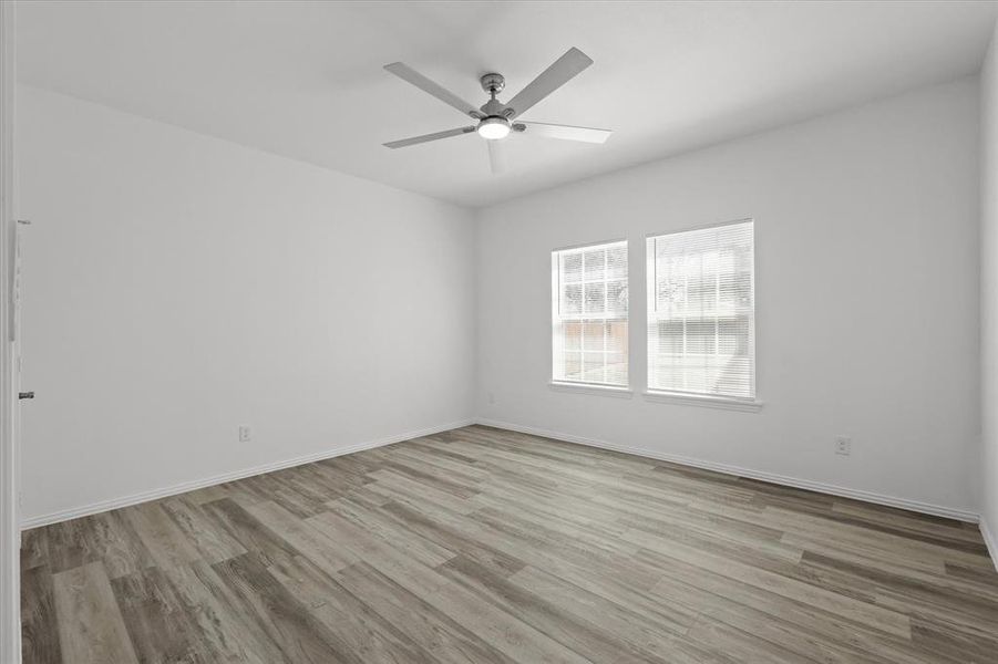 Unfurnished room with baseboards, ceiling fan, and wood finished floors