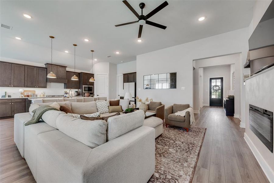 Open-concept living space featuring wood-finish flooring, recessed lighting, and a contemporary ceiling fan