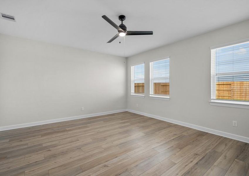 Master bedroom with plank flooring and a ceiling fan