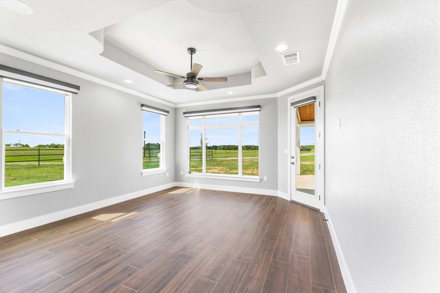 Unfurnished room with wood finish floors, a tray ceiling, a ceiling fan, crown molding, and recessed lighting Unfurnished room with wood finish floors, a tray ceiling, a ceiling fan, crown molding, and recessed lighting