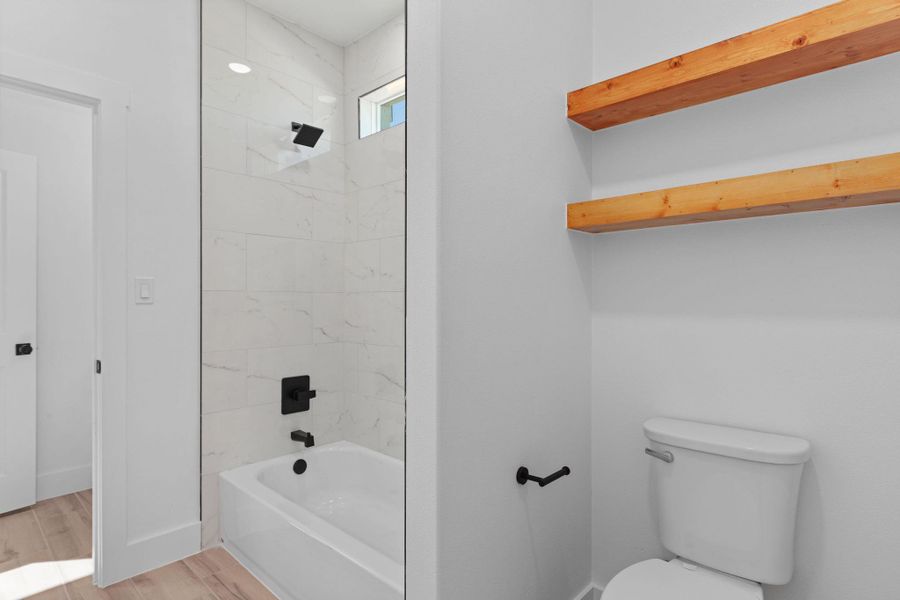 Bathroom with bathtub / shower combination and light wood finished floors Bathroom with bathtub / shower combination and light wood finished floors