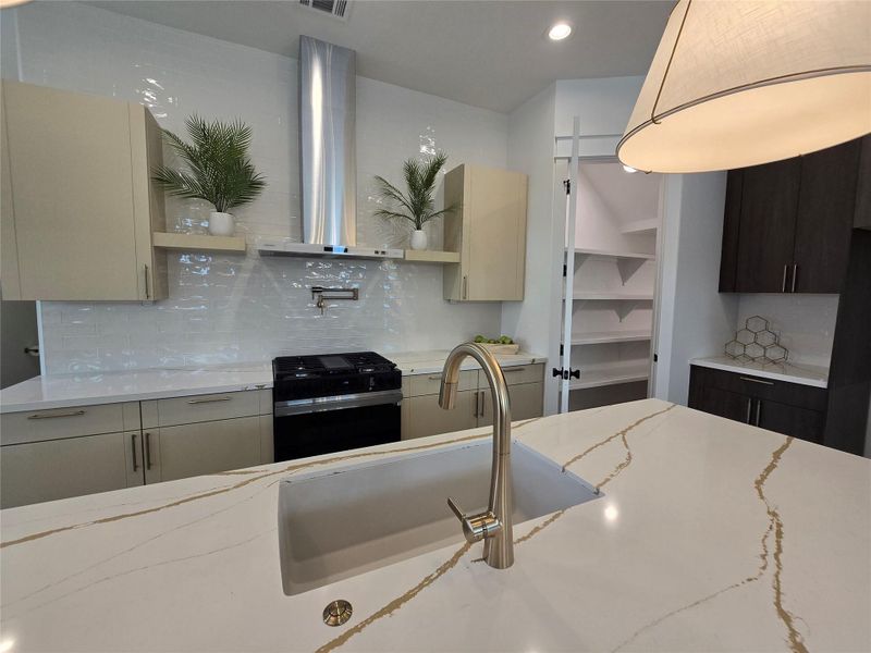 Kitchen featuring black range with gas cooktop, open shelves, a sink, backsplash, and wall chimney exhaust hood Kitchen featuring black range with gas cooktop, open shelves, a sink, backsplash, and wall chimney exhaust hood