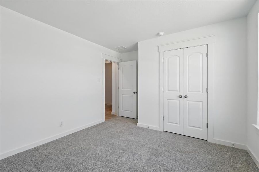 Unfurnished bedroom featuring a closet, carpet flooring, and baseboards Unfurnished bedroom featuring a closet, carpet flooring, and baseboards