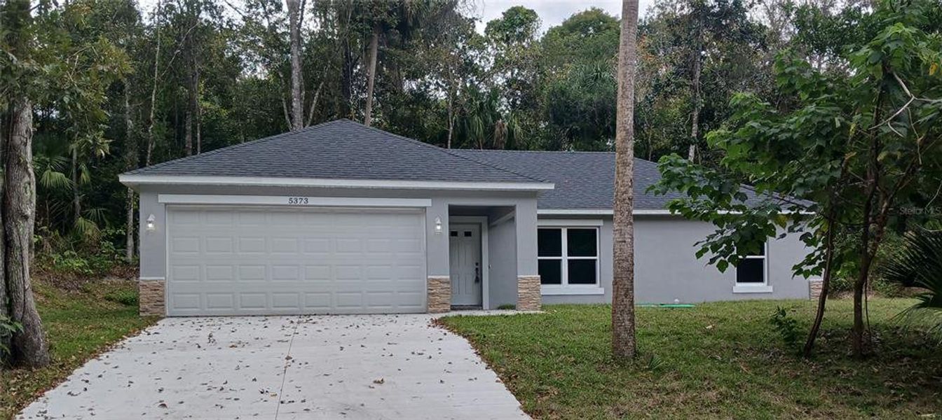 Front exterior of a new home in , De Leon Springs, FL, highlighting curb appeal (Image 1).