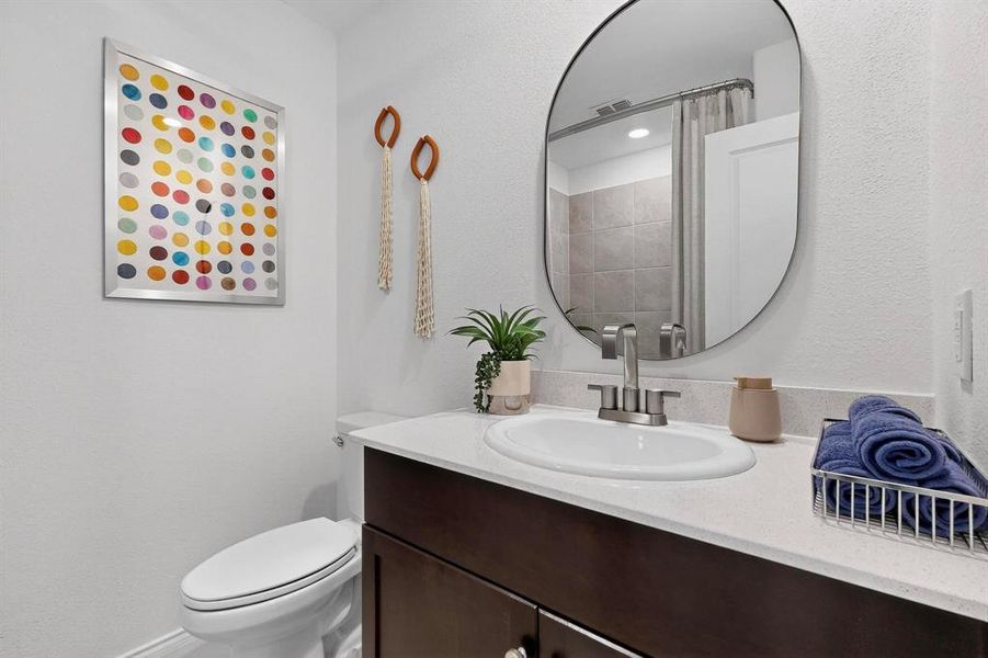 Bathroom featuring vanity, a textured wall, and a shower with curtain Bathroom featuring vanity, a textured wall, and a shower with curtain