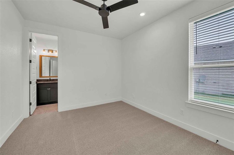 Unfurnished bedroom featuring light carpet, baseboards, ensuite bathroom, recessed lighting, and a ceiling fan