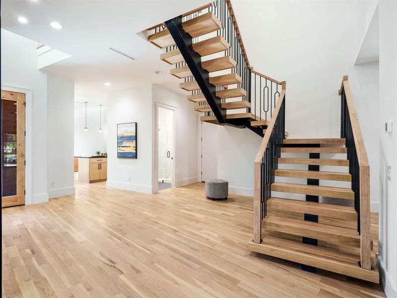 Stairway with wood finished floors and recessed lighting