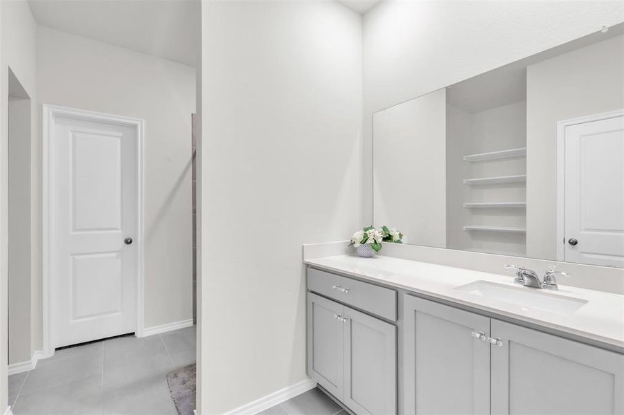 Bathroom featuring vanity, tile patterned floors, and baseboards Bathroom featuring vanity, tile patterned floors, and baseboards