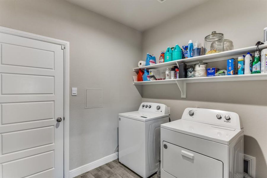 Laundry area featuring separate washer and dryer and light hardwood / wood-style flooring