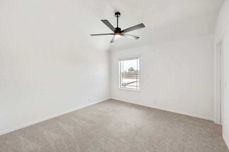 Empty bedroom with vaulted ceiling, ceiling fan, carpet flooring, and single window