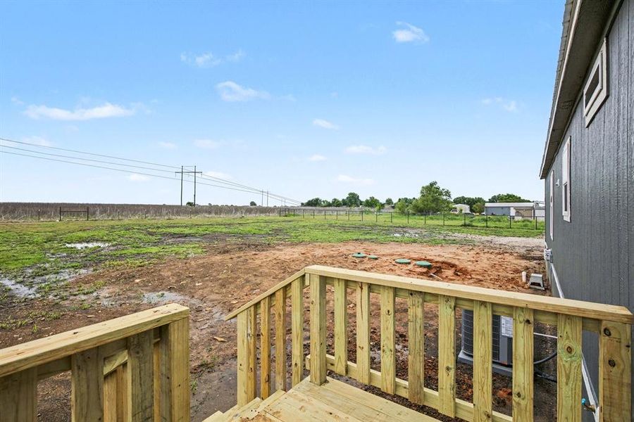 Exterior featuring a blue-grey siding facade, white trim windows, and a new wooden deck with railings