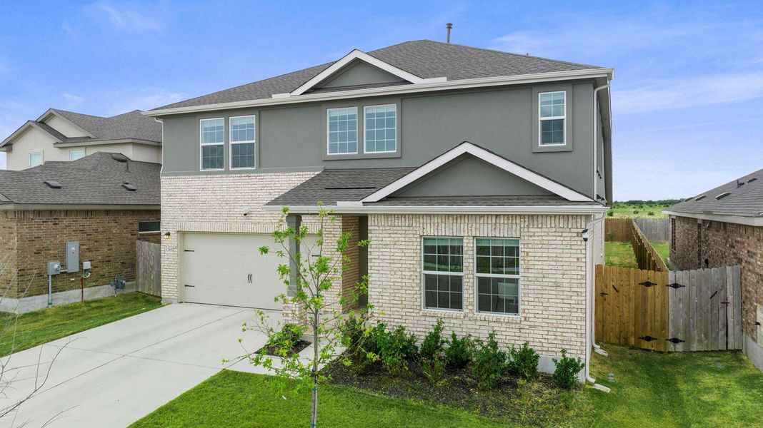 A striking two-story residence presents a dynamic facade of brick and stucco with a tidy lawn and ample driveway. A striking two-story residence presents a dynamic facade of brick and stucco with a tidy lawn and ample driveway.