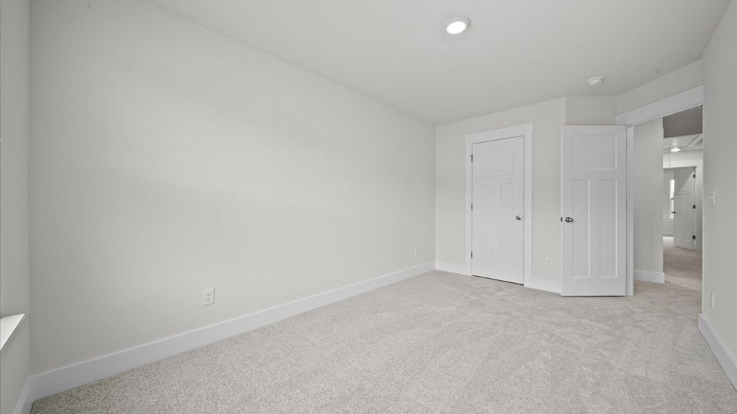 Tasteful bedroom with plush carpet, a walk-in closet, and large windows for abundant natural light Tasteful bedroom with plush carpet, a walk-in closet, and large windows for abundant natural light