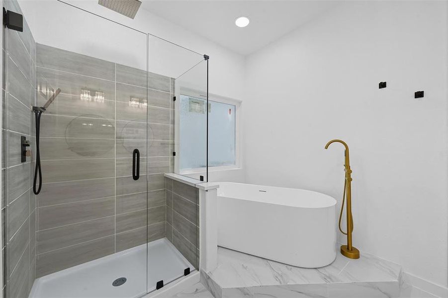 Full bathroom with a shower stall, a freestanding bath, marble look tile flooring, and recessed lighting Full bathroom with a shower stall, a freestanding bath, marble look tile flooring, and recessed lighting