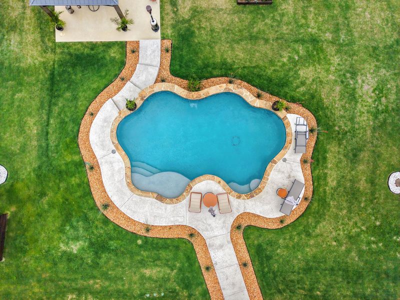 An inviting backyard oasis offers a unique pool and generous lounging space. An inviting backyard oasis offers a unique pool and generous lounging space.
