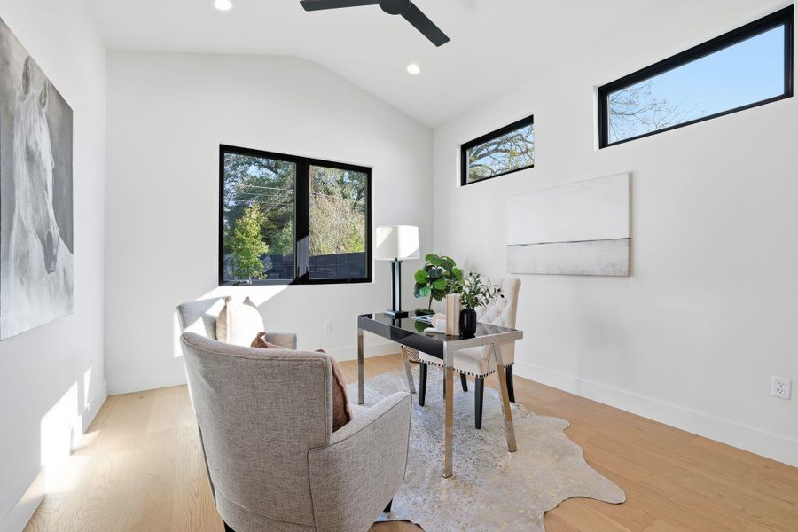 Office area with vaulted ceiling, light wood finished floors, recessed lighting, and a ceiling fan