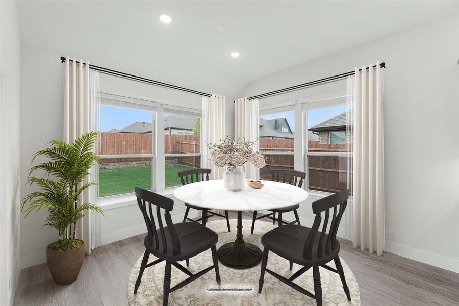 Bright breakfast nook with round marble table, four black chairs, and large windows overlooking a backyard.