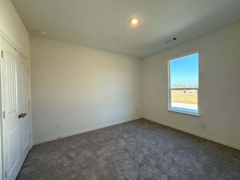 Unfurnished bedroom featuring dark carpet, a closet, and recessed lighting