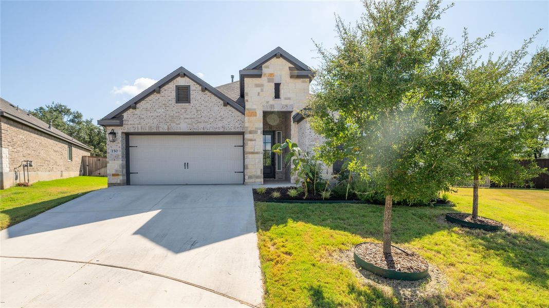French provincial home featuring driveway, brick siding, a garage, and stone siding French provincial home featuring driveway, brick siding, a garage, and stone siding