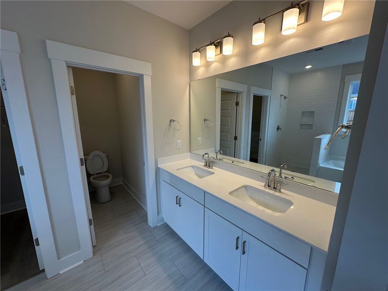 This modern bathroom features a dual vanity and a