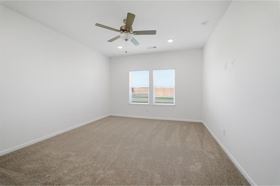Carpeted spare room with baseboards and ceiling fan