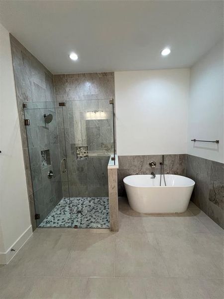 Bathroom with tile patterned flooring and shower with separate bathtub