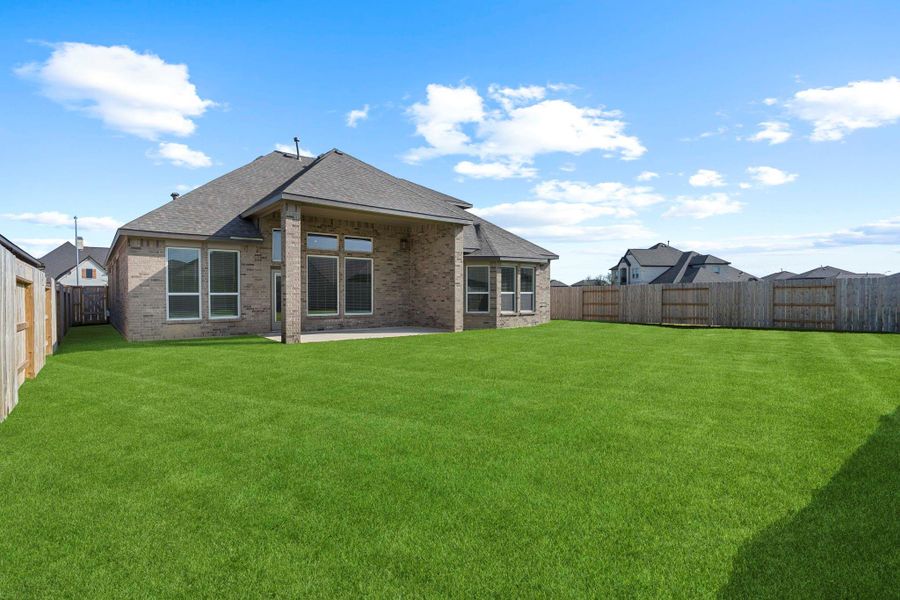 Rear exterior view highlights the covered patio, expansive windows, and large fenced backyard—perfect for outdoor living. Almost all brick exterior for less upkeep! Rear exterior view highlights the covered patio, expansive windows, and large fenced backyard—perfect for outdoor living. Almost all brick exterior for less upkeep!