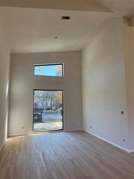 Empty room with a high ceiling and light wood finished floors Empty room with a high ceiling and light wood finished floors