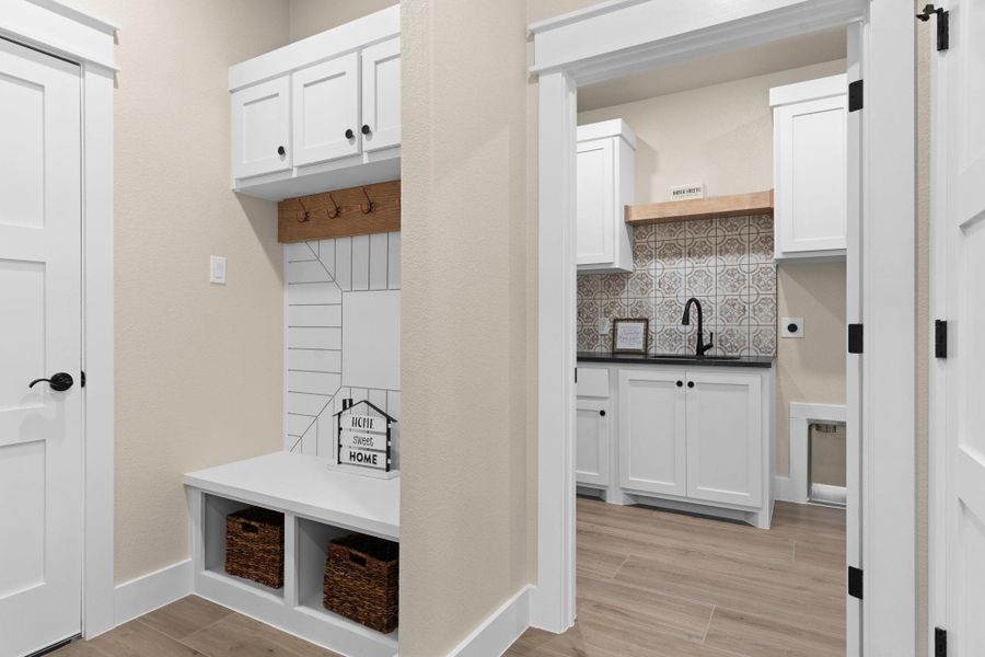Mudroom featuring a sink, baseboards, and light wood-style floors Mudroom featuring a sink, baseboards, and light wood-style floors