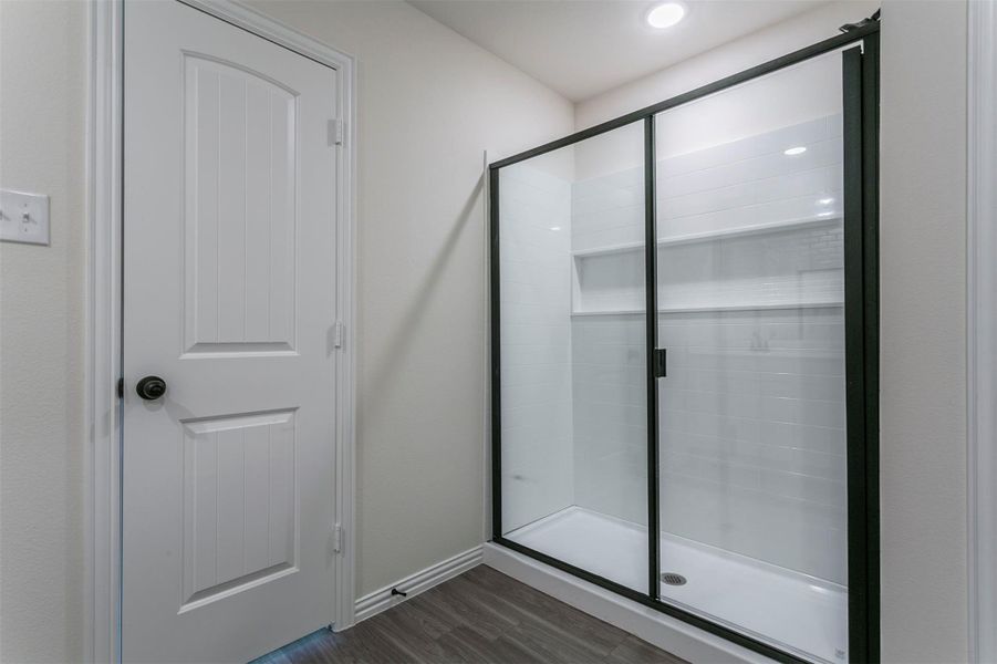 Full bath with a shower stall, baseboards, wood finished floors, and recessed lighting Full bath with a shower stall, baseboards, wood finished floors, and recessed lighting