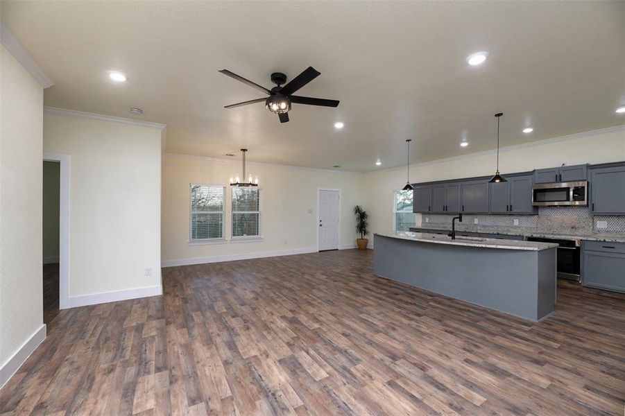 Light and bright with canned lighting, pendant lighting over the center island and also under cabinet lighting in the kitchen.