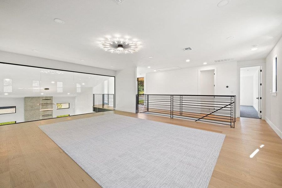 Upstairs you will find an entertainer's game and media lounge with a glass wall overlooking the main floor below.