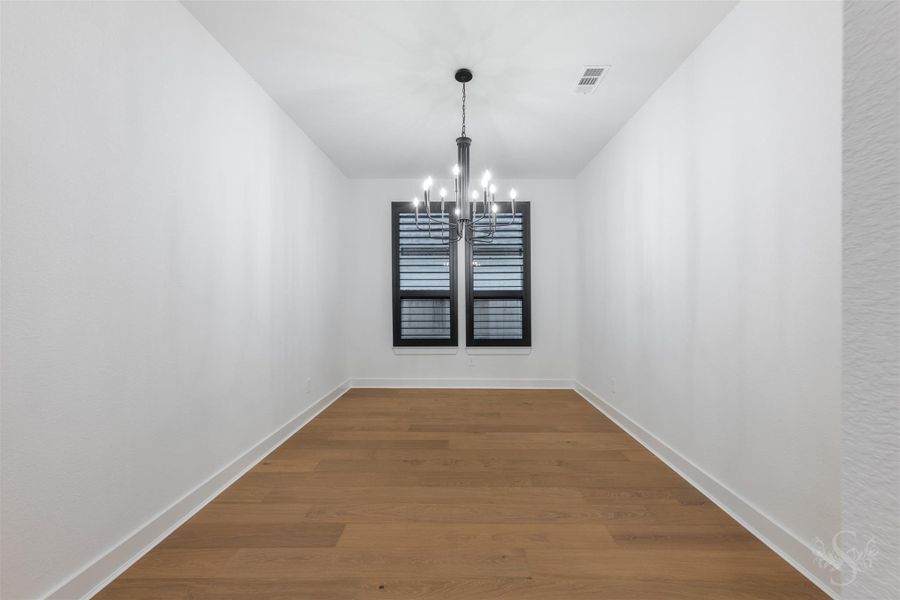 Formal dining room with upgraded chandelier and striking black plantation shutters. Formal dining room with upgraded chandelier and striking black plantation shutters.