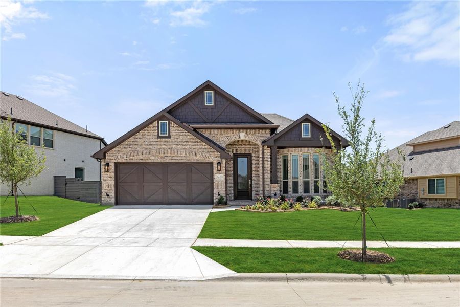 Single-story brick home with dark brown trim, two-car garage, and landscaped front yard Single-story brick home with dark brown trim, two-car garage, and landscaped front yard