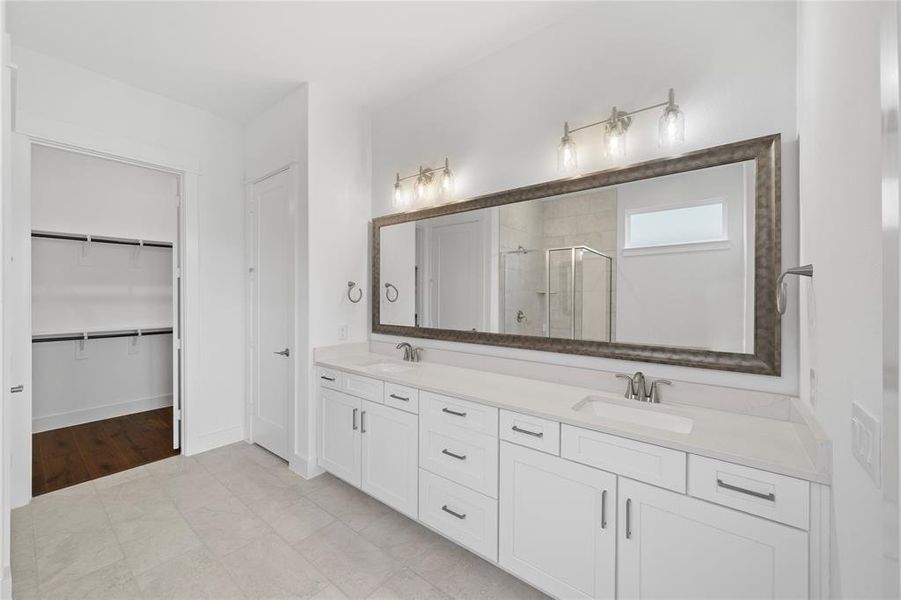 Spacious bathroom featuring a dual vanity with white cabinetry and light-toned countertops