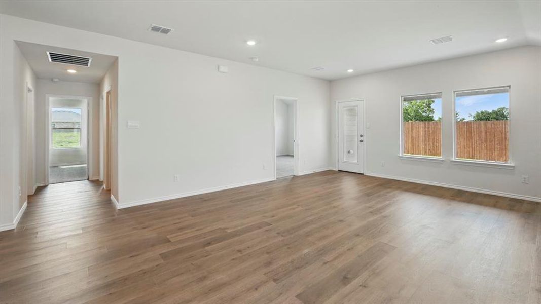Unfurnished living room with plenty of natural light, recessed lighting, and dark wood-type flooring