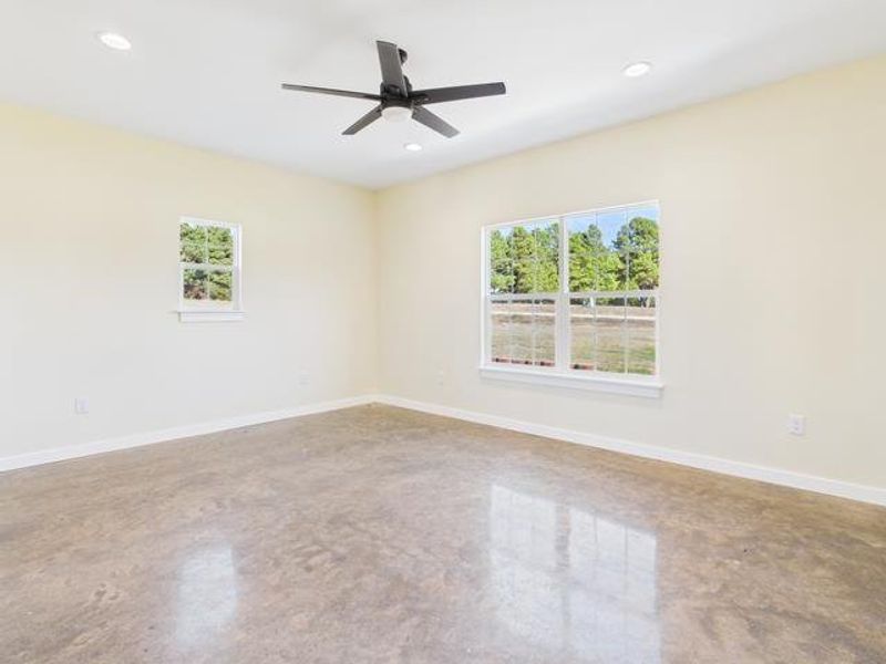 Before Photo featuring plenty of natural light, concrete floors, and ceiling fan