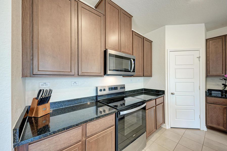 Granite counters and rich wood cabinetry define this well-appointed kitchen.
