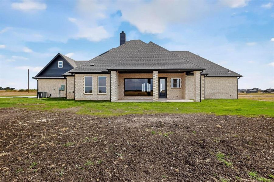 Rear view of property with brick siding, a patio area, and a lawn Rear view of property with brick siding, a patio area, and a lawn